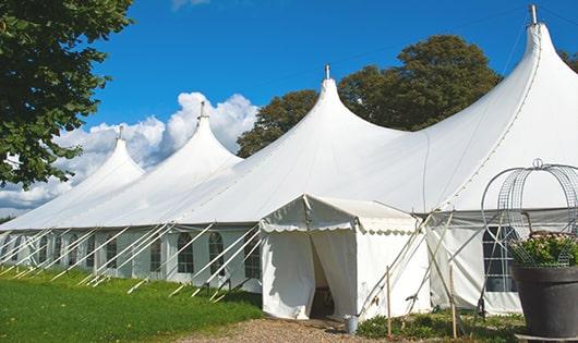 a line of portable restrooms in a shaded area, offering a comfortable experience for users in Manchester